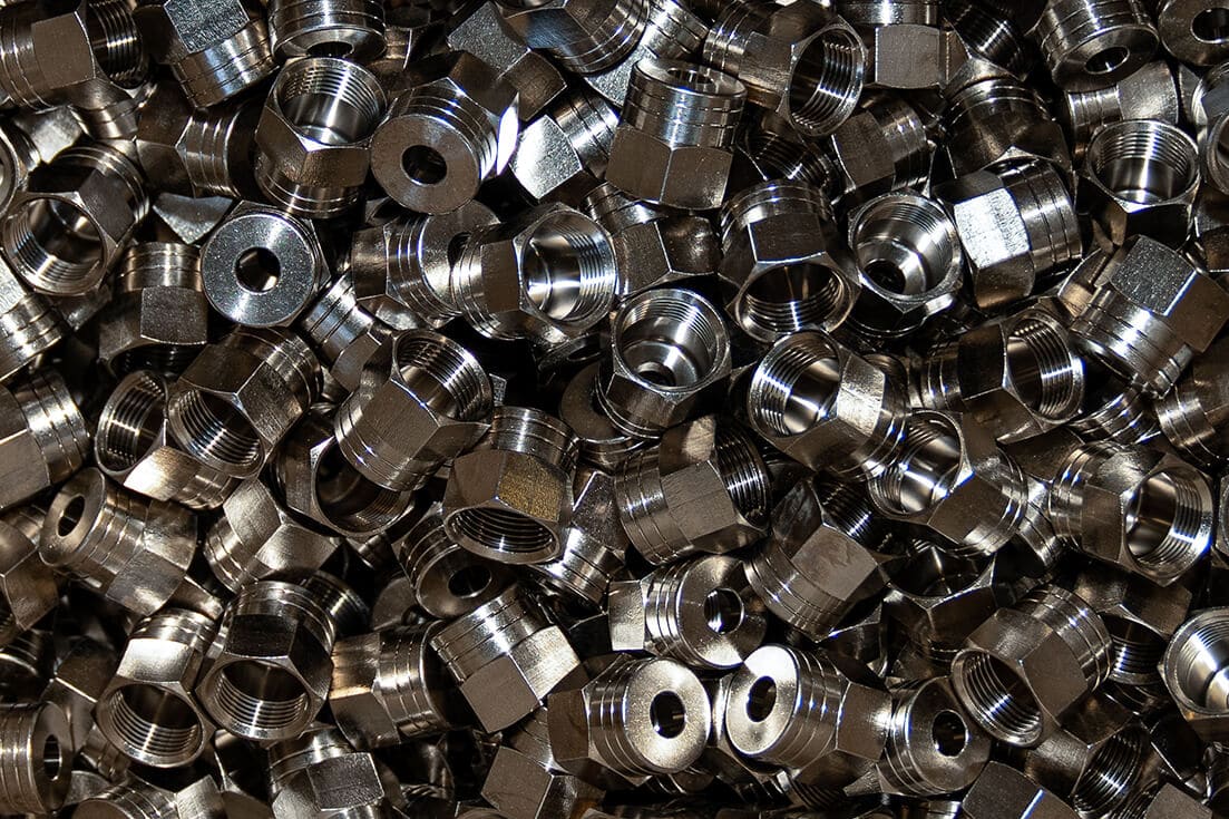 Pile of plated threaded steel fittings