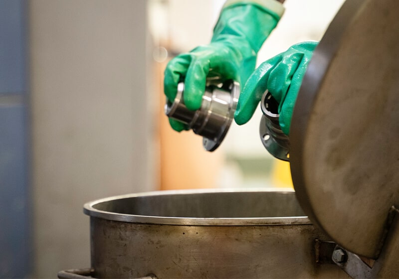 A man de-greasing some metal components
